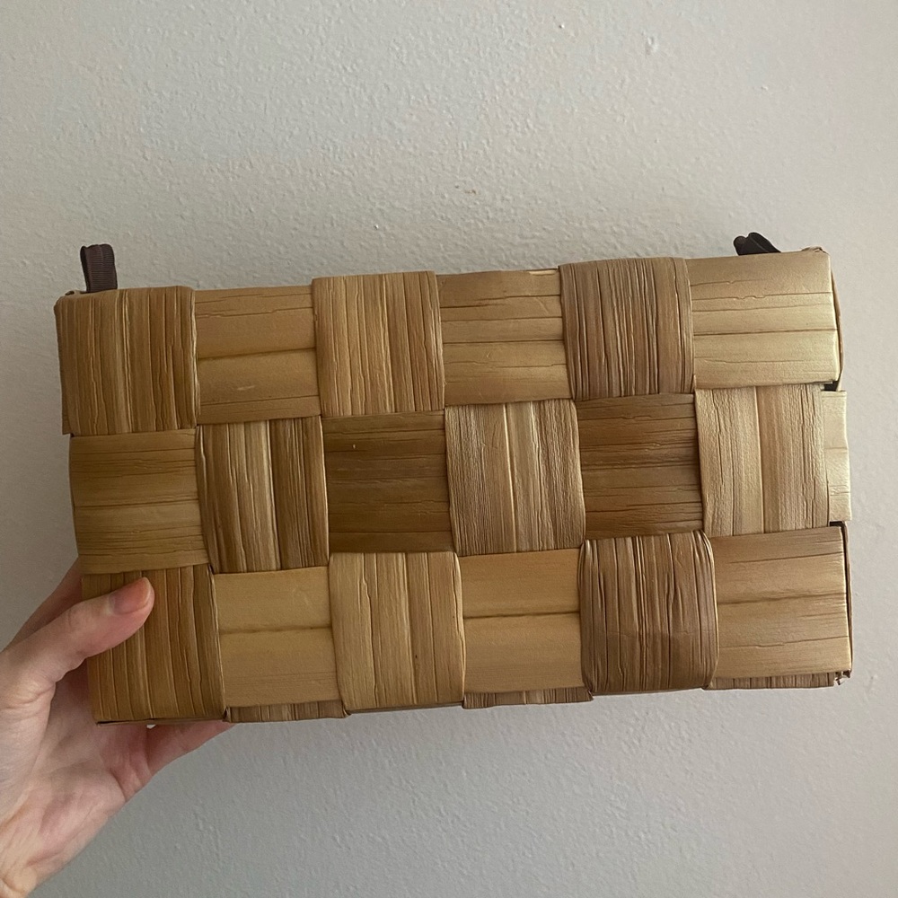 One-of-a-kind bamboo-style woven clutch. Attachments for ability to add strap